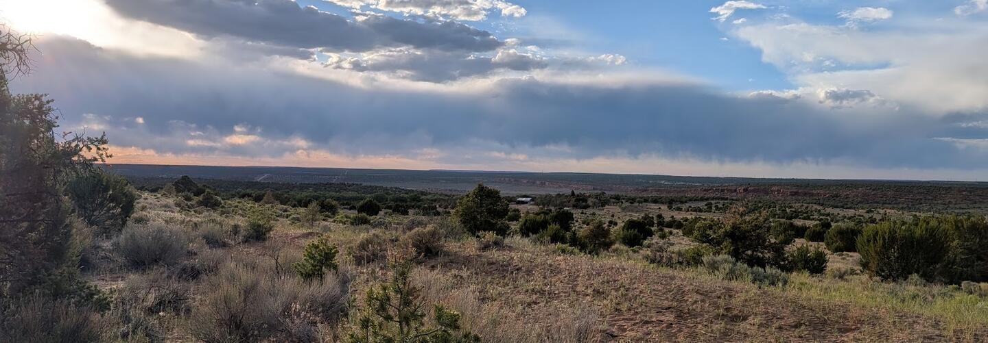 A wide view across the valley under a long bank of storm cloud